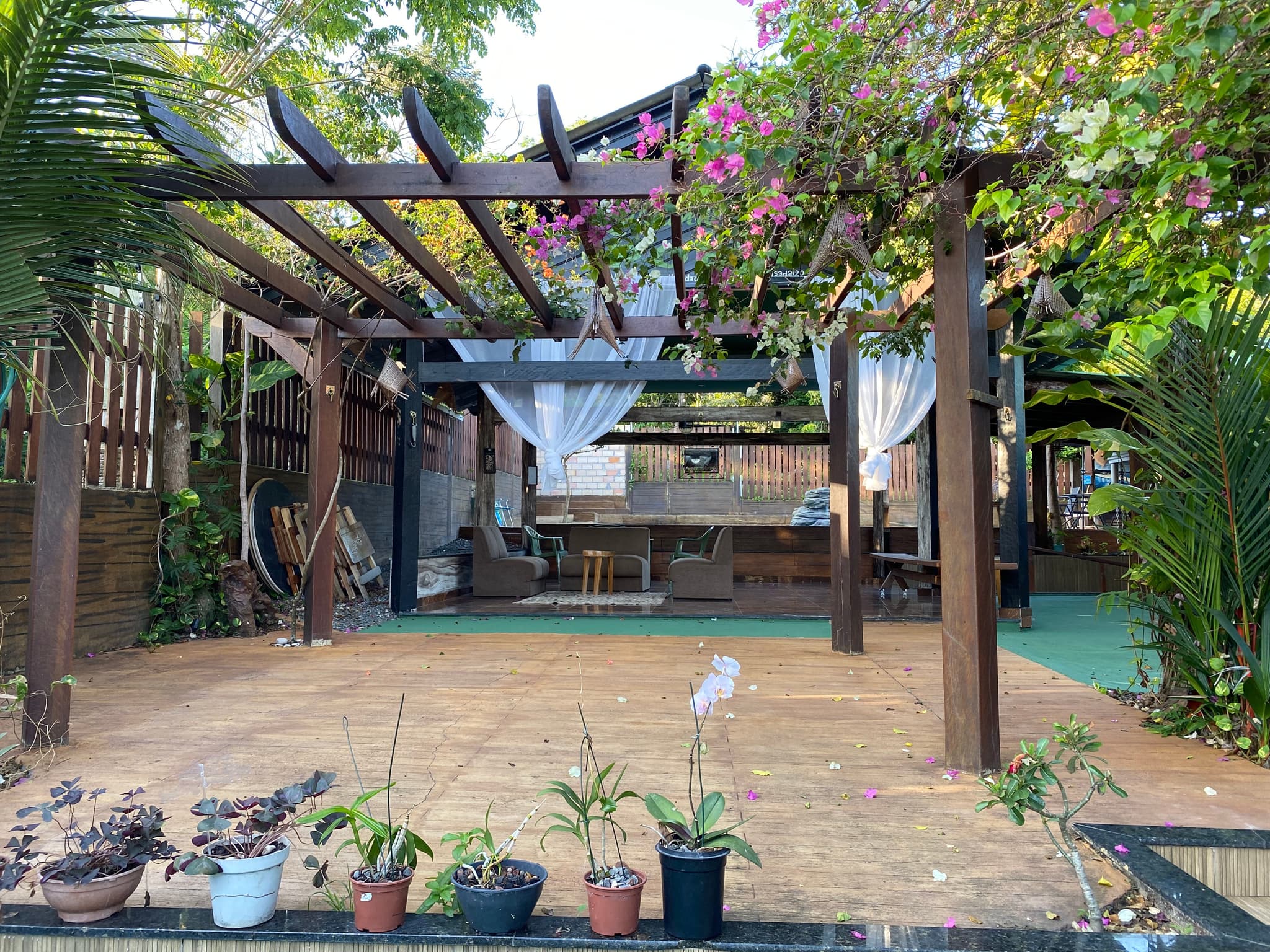 Pergolado com flores e área de convivência